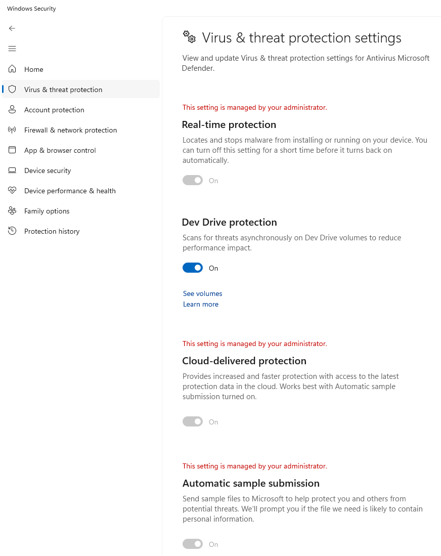 Real capture of Windows Security Manage settings page, showing Real-time protection, Dev Drive protection and Cloud-delivered protection all On, with several marked as managed by the administrator